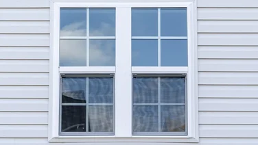A view of a uPVC window on a white wooden building