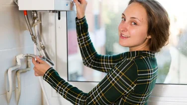 a woman adjusts her combi boiler