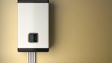 An electric boiler against a beige background