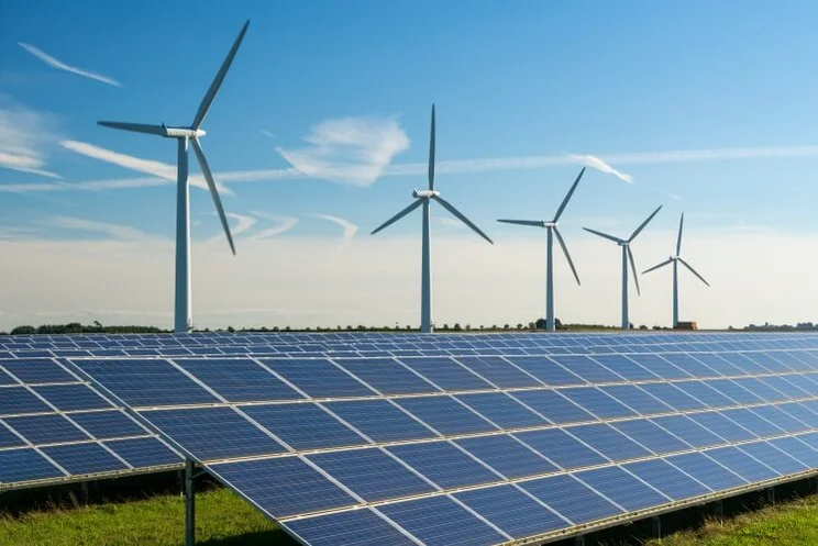 wind turbines and solar panels against a blue sky
