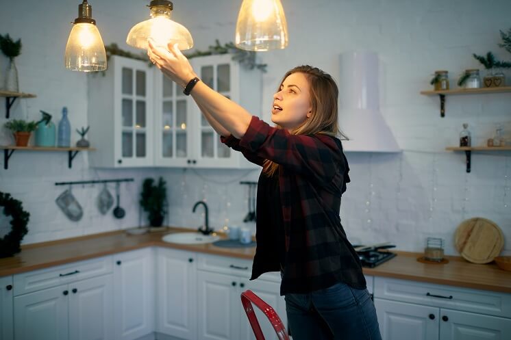 Person changes lightbulb for LEDs