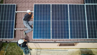 People installing solar panels on a roof
