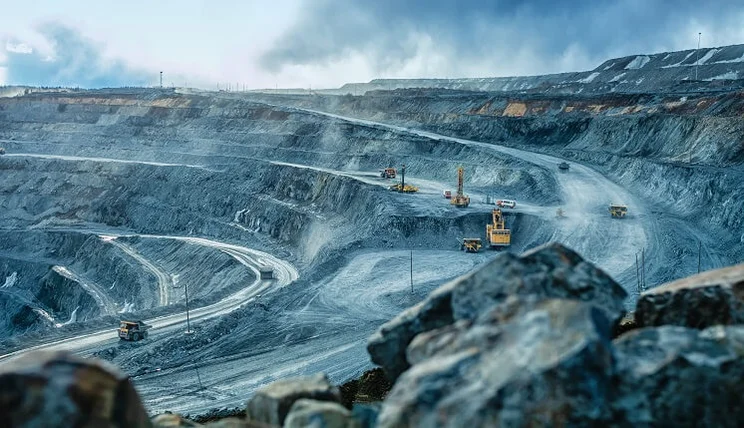 Work trucks excavating a pit for mining work