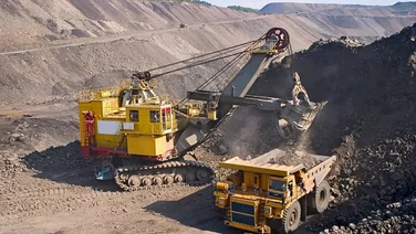 Yellow trucks digging up dirt to build a mine