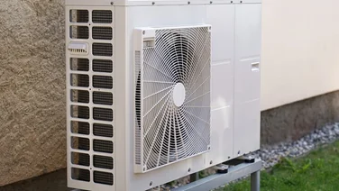 white air source heat pump unit outside house